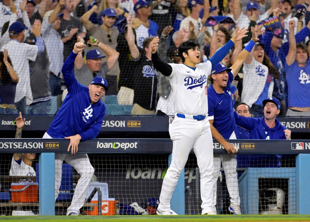 Dodgers designated hitter Shohei Ohtani (17) celebrates with pitcher Clayton Kershaw (22) and first baseman Freddie Freeman (5) in the dugout