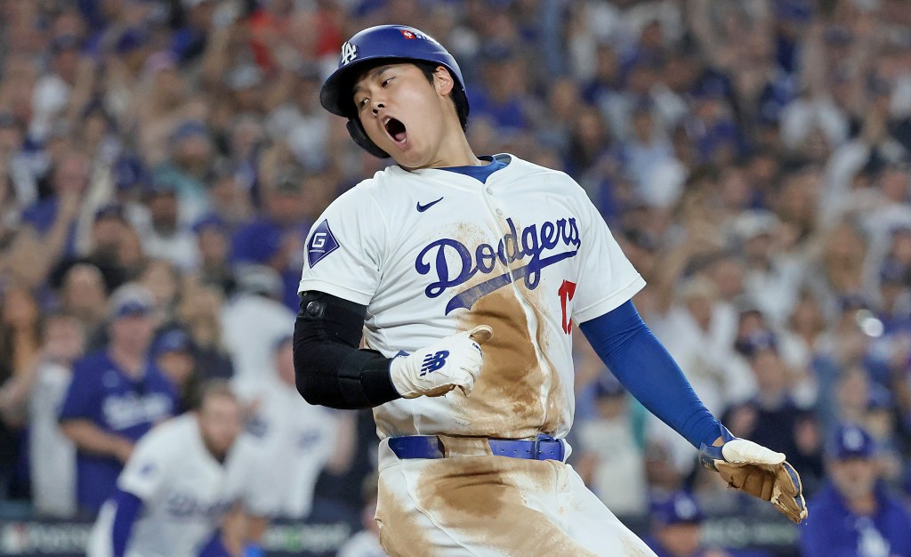 Shohei Ohtani of the Los Angeles Dodgers reacts as he scores on an RBI single by Freddie Freeman during the fourth inning.