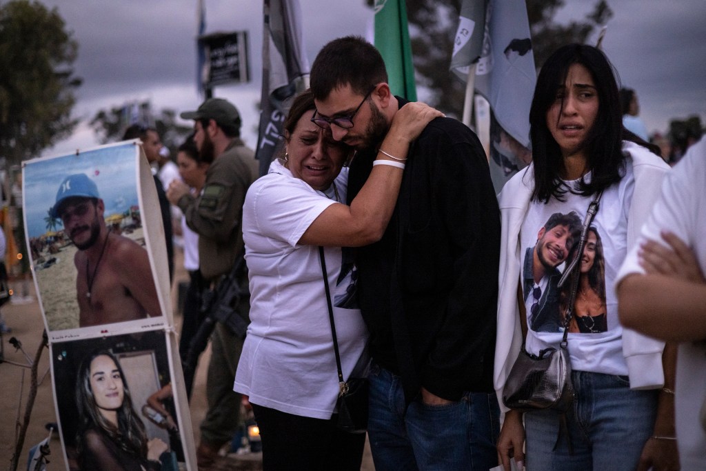 Two people embracing at a candlelight vigil marking the first anniversary of the October 7 Hamas attack in Southern Israel