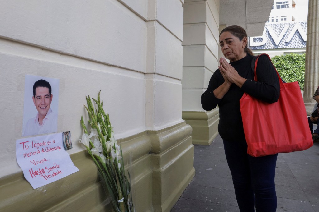 A mourning woman paying her respects at a memorial for Arcos. 