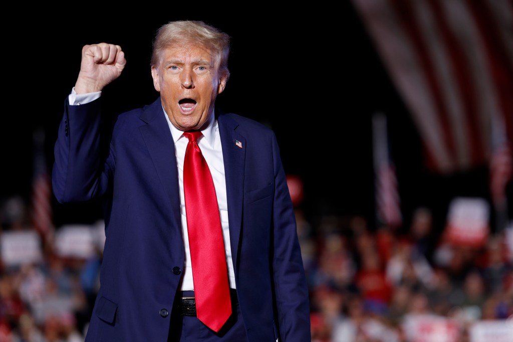 Republican presidential nominee, former President Donald Trump holds up his fist as he walks offstage at the end of a campaign rally at the Butler Farm Show fairgrounds on October 05, 2024 in Butler, Pennsylvania. 