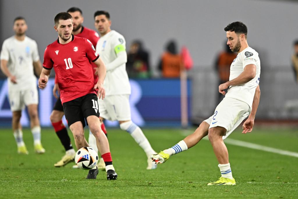 Greece's George Baldock, right, takes a free-kick during the Euro 2024 qualifying play-off soccer match between Georgia and Greece