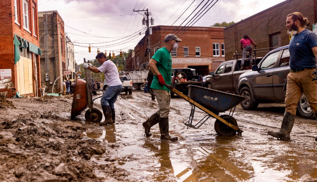 Residents and volunteers cleaning up a muddy area in downtown Marshall, North Carolina, after widespread flooding from the remnants of Hurricane Helene