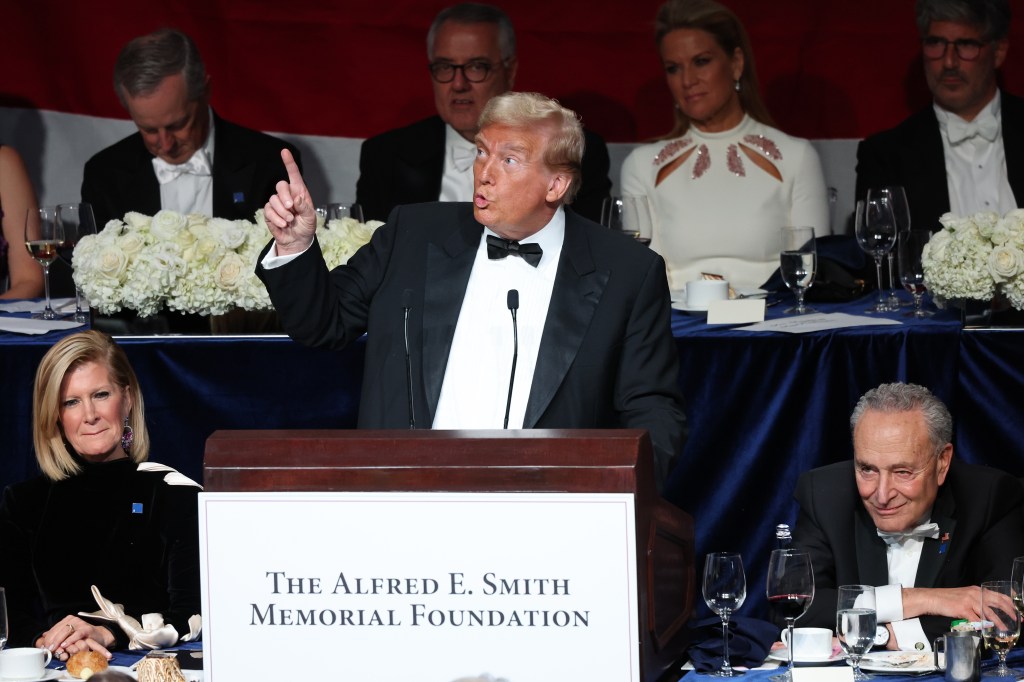 Former President Donald Trump giving a speech at the Alfred E. Smith Dinner in New York City, with celebrities including Charles Ellis Schumer and Martha MacCallum in attendance