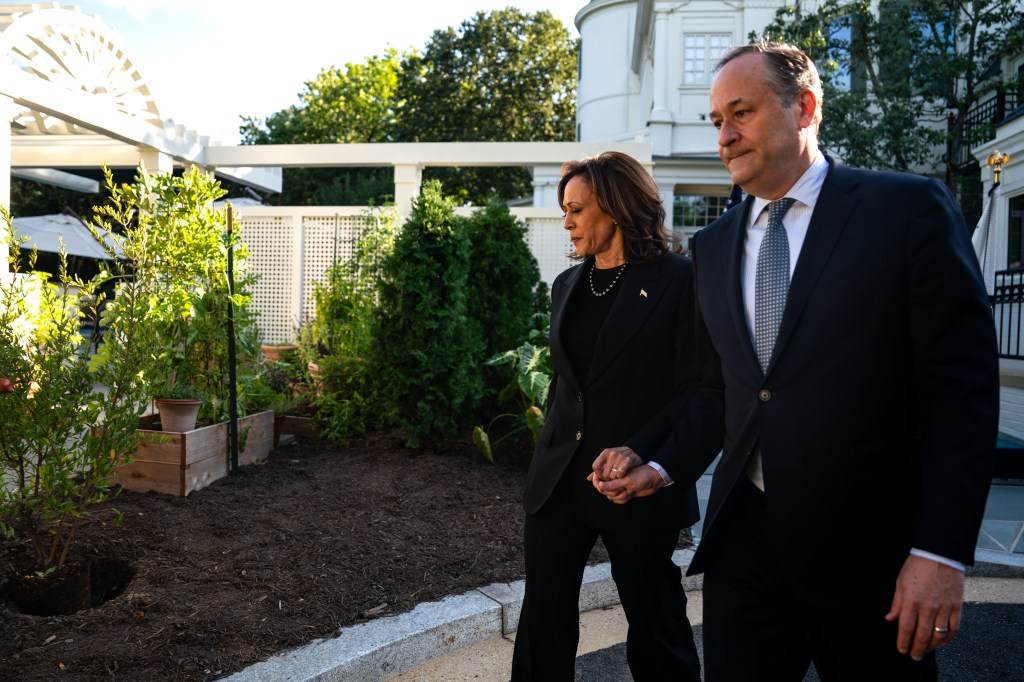 Vice President Kamala Harris and Second Gentleman Doug Emhoff holding hands and walking towards a planting spot for a pomegranate tree at the Vice President's residence in Washington, DC