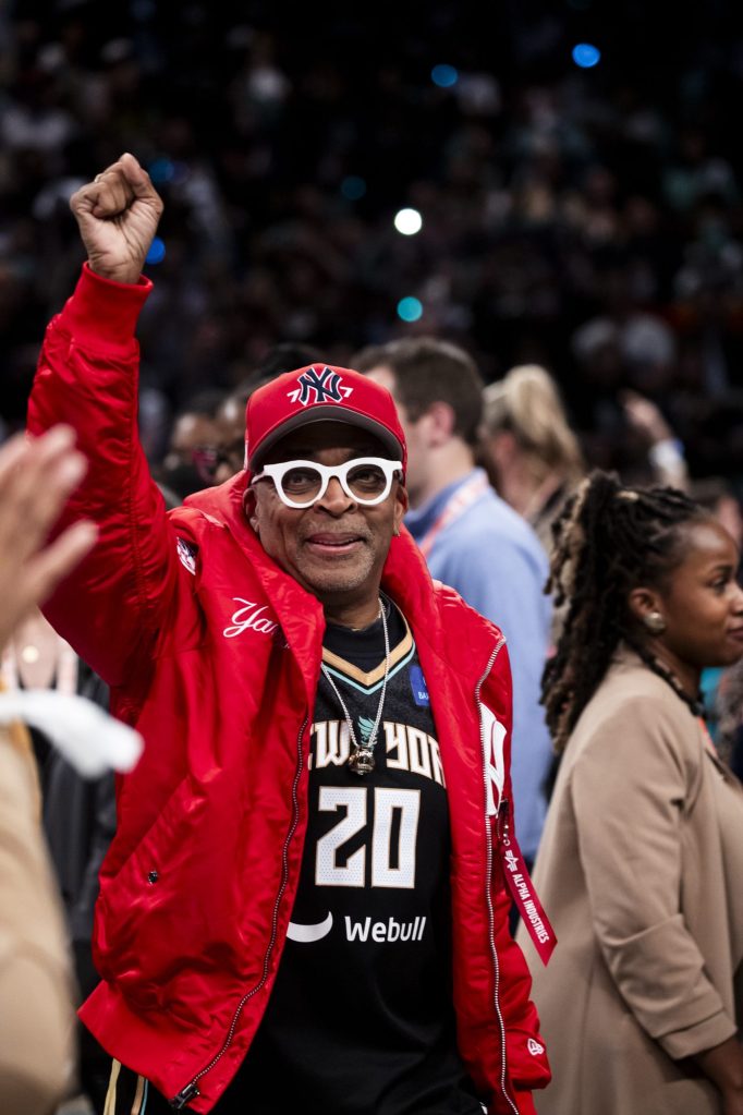 Spike Lee in a red jacket and white glasses reacting to New York Liberty's victory over Minnesota Lynx in the 2024 WNBA Finals Game 5 at Barclays Center