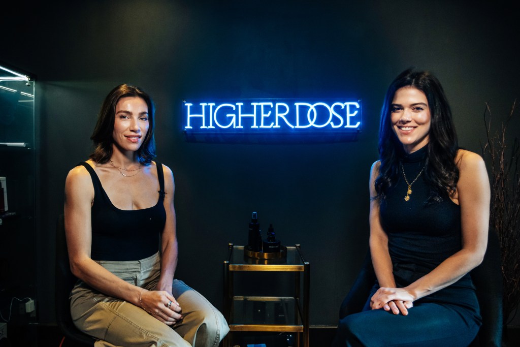 Co-Founder of Higher Dose, Lauren Berlingeri, and Lydia Moynihan sitting in front of a neon sign at the Howard Hotel in Manhattan on September 17, 2024