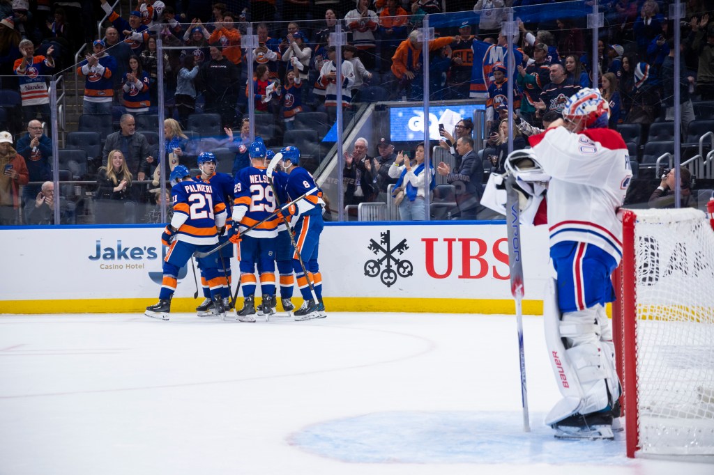 Montreal Canadiens goaltender Cayden Primeau (30) looks on as New York Islanders center Kyle Palmieri (21) celebrates his goal with the team  during the first period at UBS Arena, Saturday, Oct. 19, 2024, in Elmont, NY. 