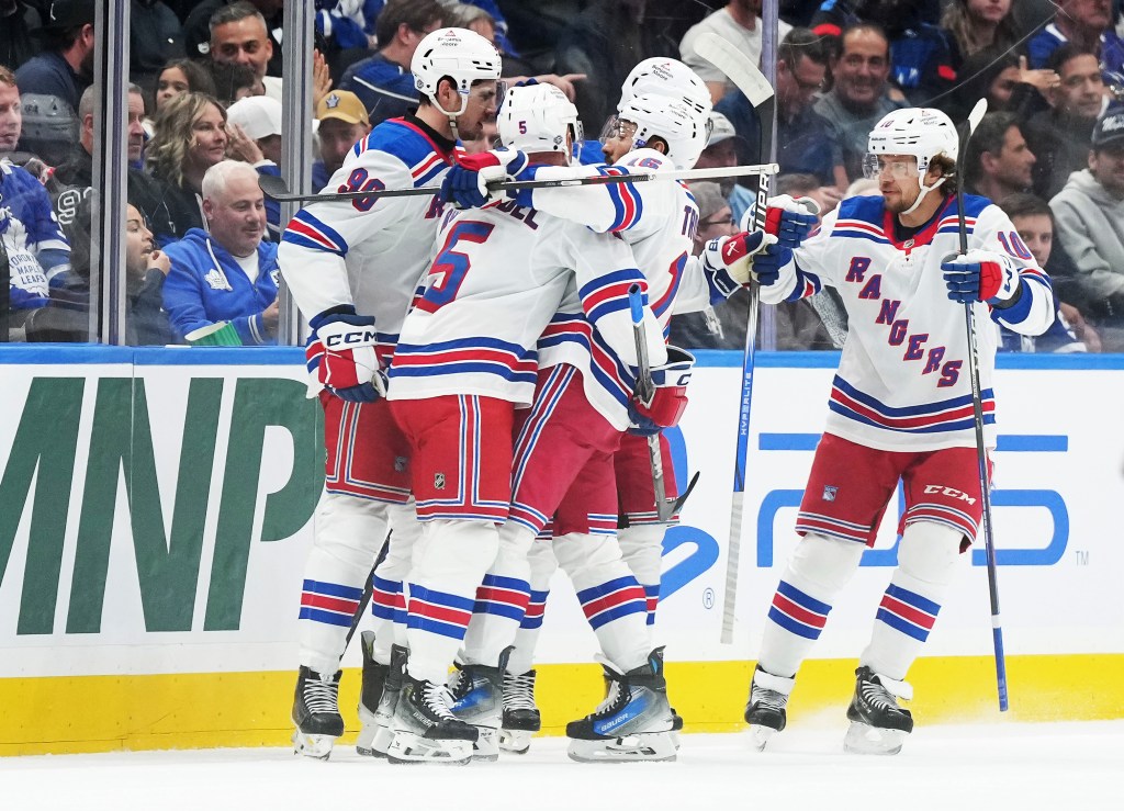 New York Rangers defenseman Chad Ruhwedel (5) celebrates with center Vincent Trocheck (16) after left wing Alexis Lafreniere (13) (not pictured) scored a goal against the Toronto Maple Leafs during the first period at Scotiabank Arena. 