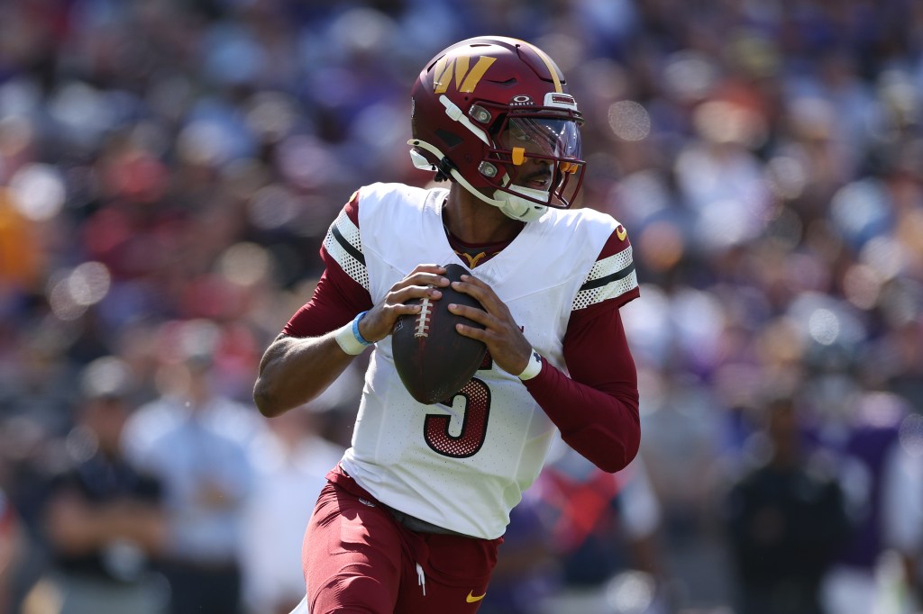 Quarterback Jayden Daniels #5 of the Washington Commanders rushes with the ball against the Baltimore Ravens at M&T Bank Stadium on October 13, 2024 in Baltimore, Maryland.