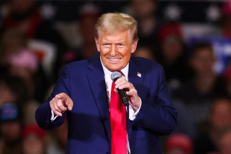 Former US President Donald Trump speaking at a town hall in Lancaster, Pennsylvania, holding a microphone, October 20, 2024