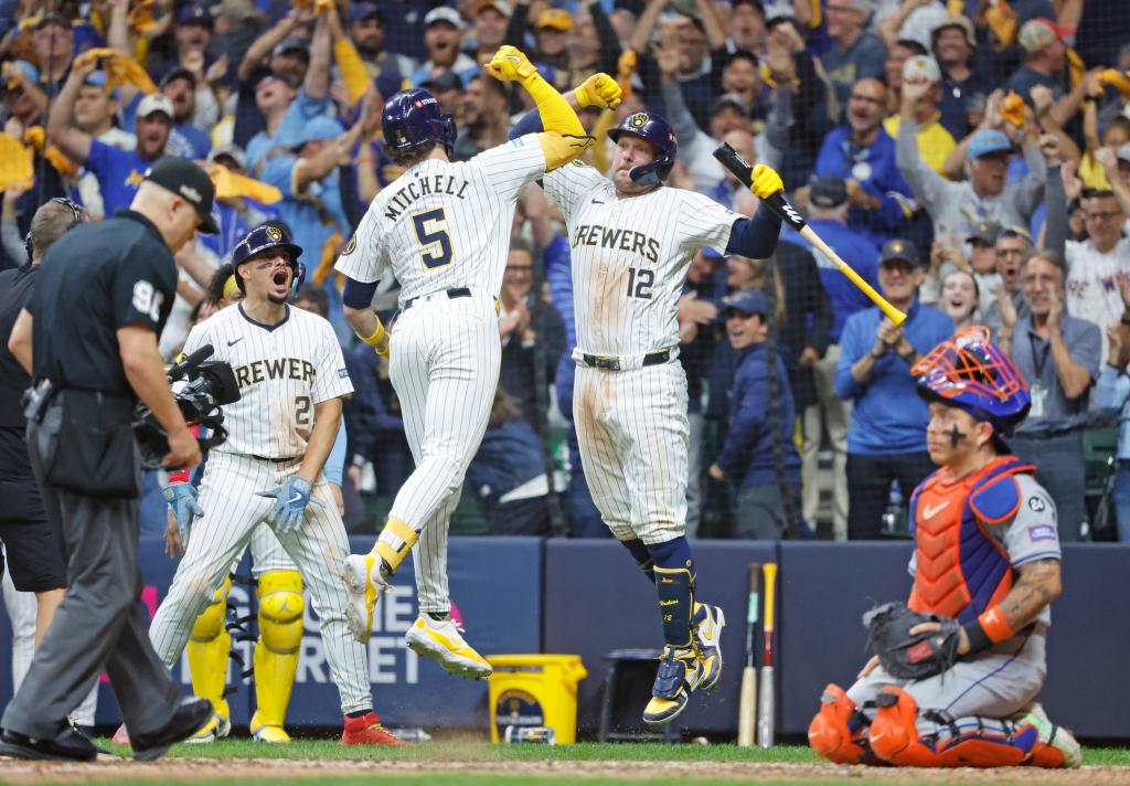 #5 of the Milwaukee Brewers celebrates with Rhys Hoskins #12 of the Milwaukee Brewers after he scores on his two-run home run during the 8th inning. The Milwaukee Brewers defeated the Mets.