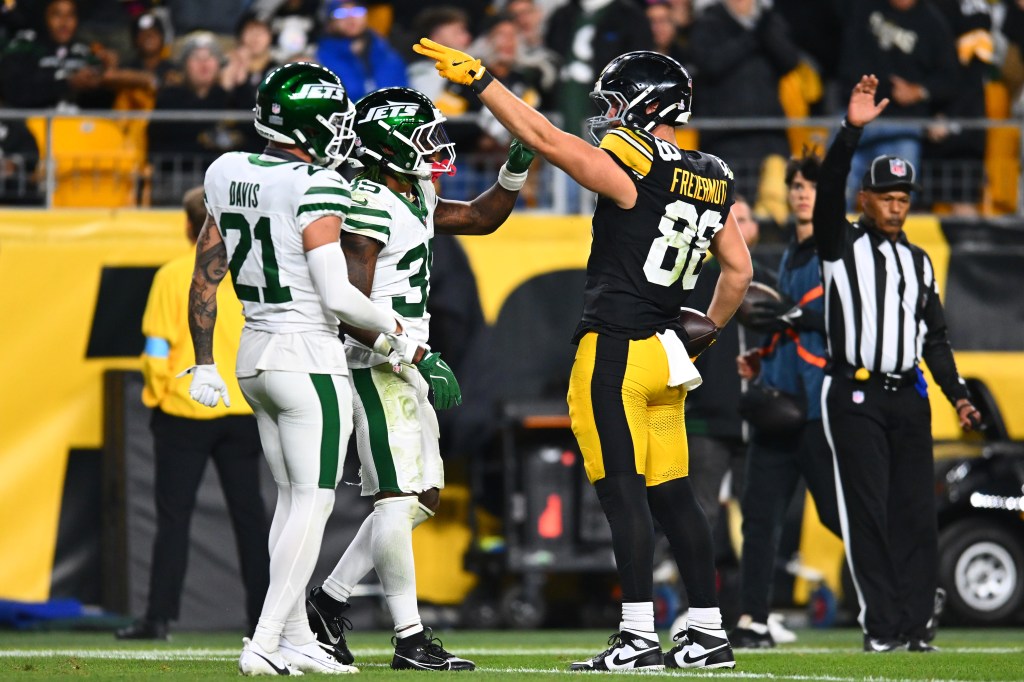 Pat Freiermuth #88 of the Pittsburgh Steelers reacts after a first down in front of Jalen Mills #35 and Ashtyn Davis #21 of the New York Jets