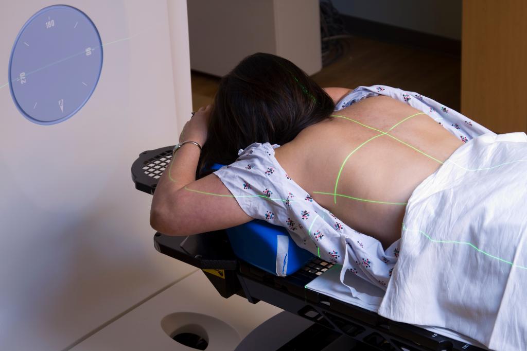 A woman undergoing radiation therapy treatment for lung cancer on a medical bed