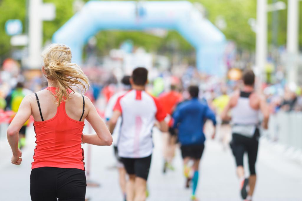 Woman starting or finishing a marathon with a group of people