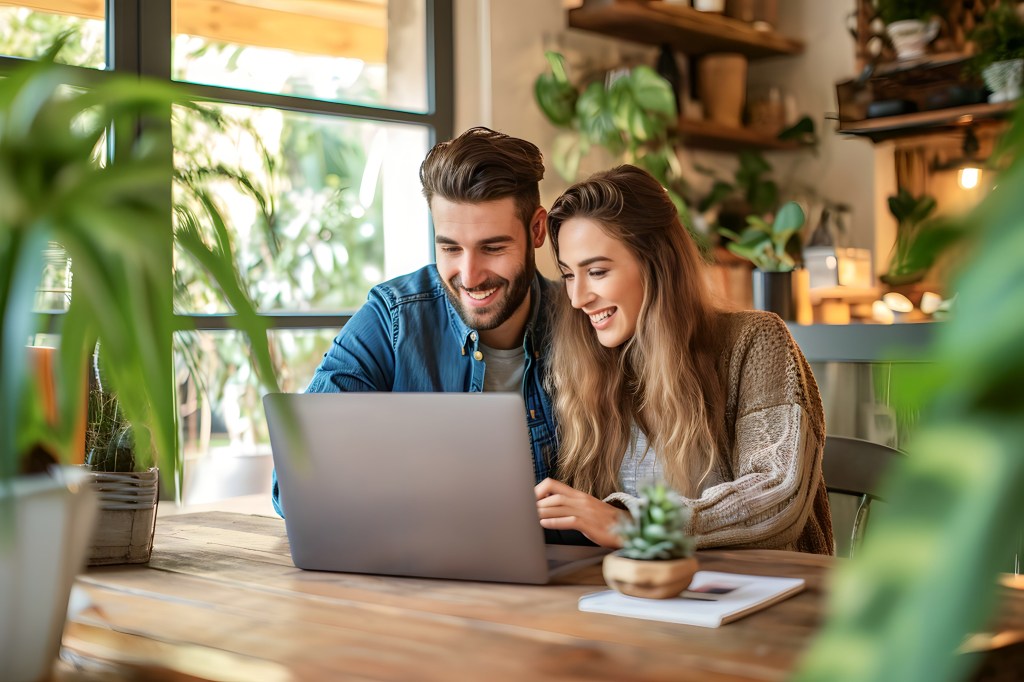 Caucasian young couple, including Tino Sunseri, viewing a laptop together