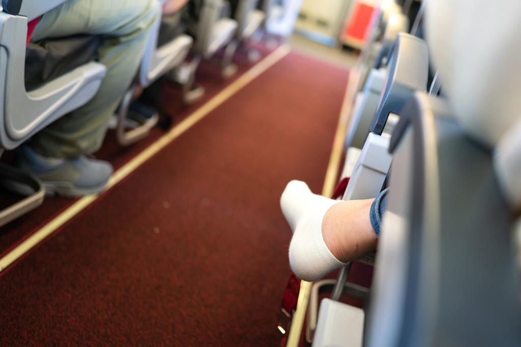 A woman without shoes on a plane. 