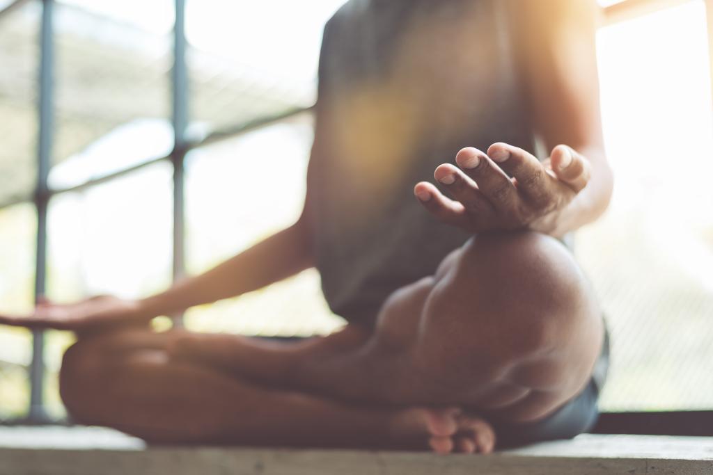 Young Asian man practicing meditation indoors for healthy lifestyle