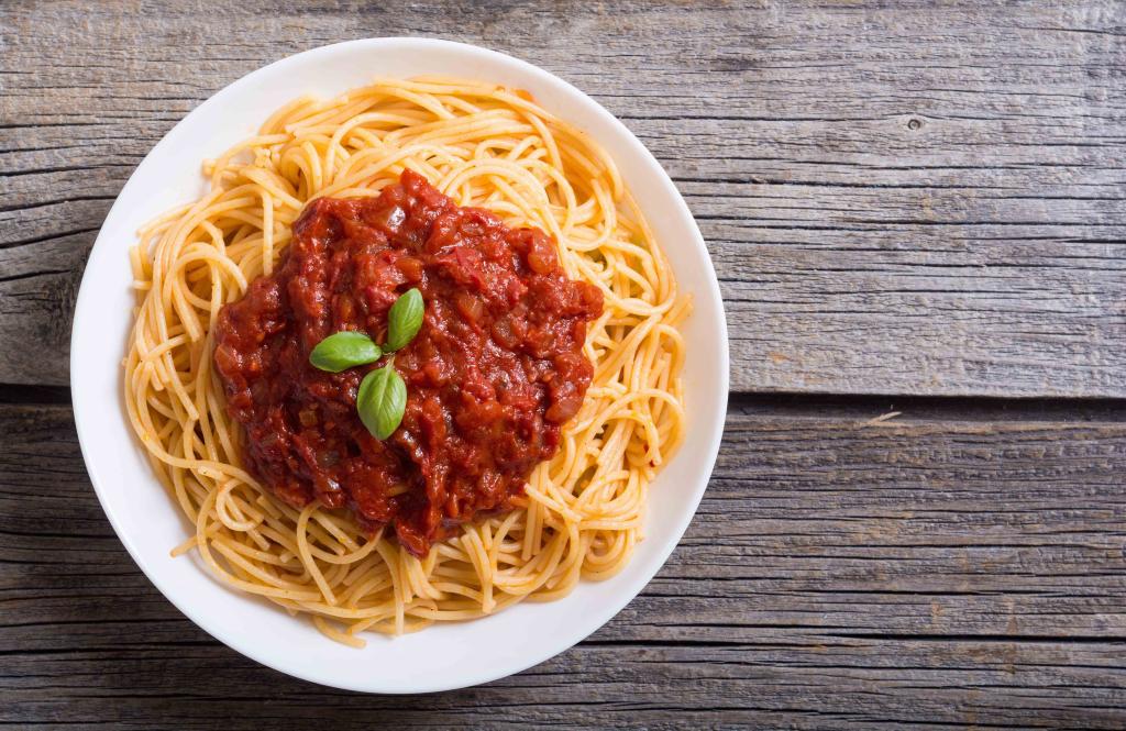 A plate of spaghetti with tomato sauce and basil.