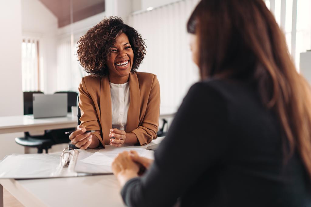 Female financial advisor consulting a client at the meeting and having business conversation or making offer