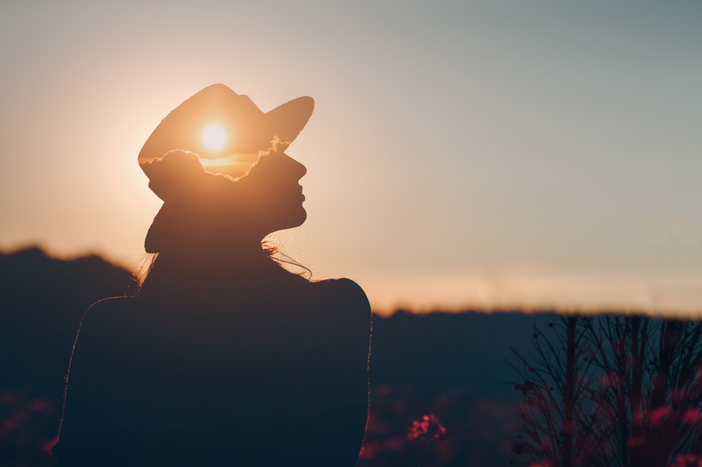 Silhouette of a young adult businesswoman contemplating mental health and business