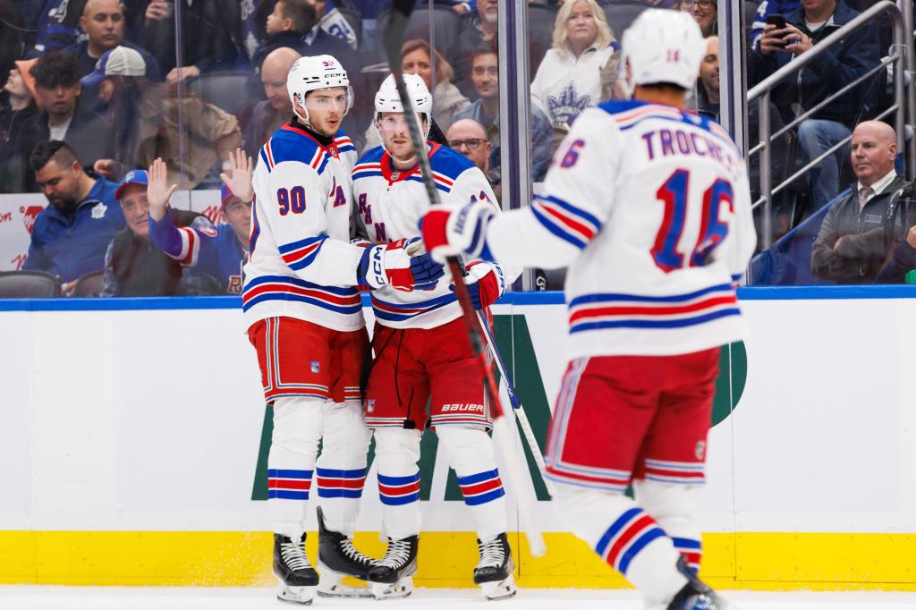 Alexis Lafreniere (center) accepts congratulations from Victor Mancini (left) and Vincent Trocheck after scoring a first-period goal in the Rangers' win.