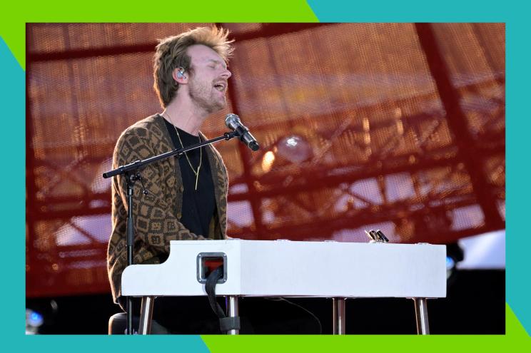 Finneas sings while playing the keyboard in concert.