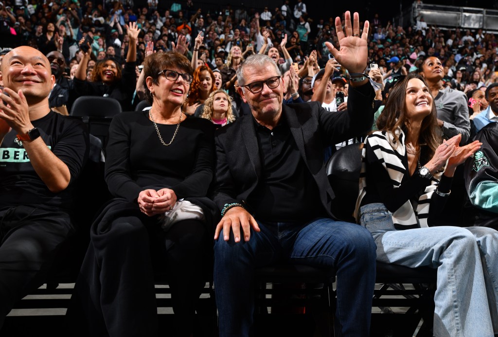 UConn women's basketball coach Geno Auriemma waves to the crowd during the Liberty's Game 2 win over the Lynx at Barclays Center.