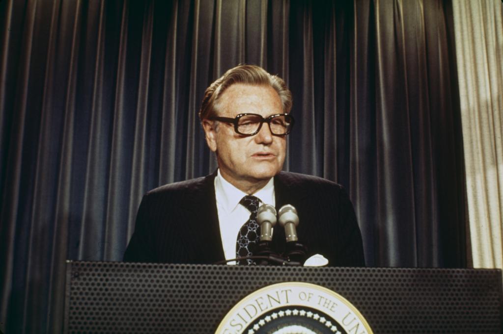 Vice President Nelson Rockefeller delivering his acceptance speech at the White House in 1974, standing at a podium with microphones