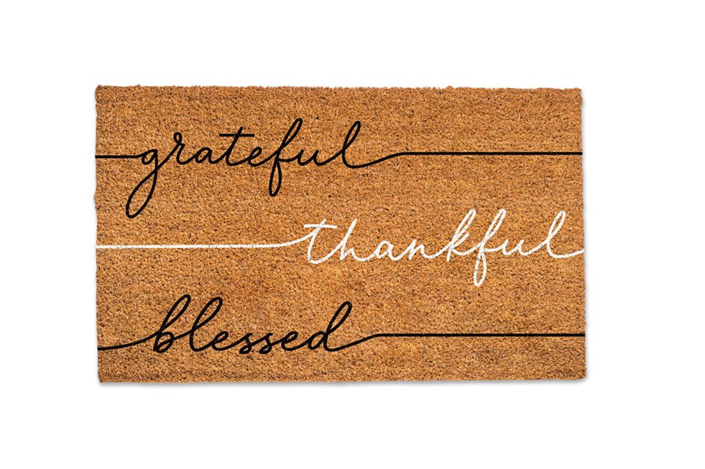 A brown and white doormat with the words 'Grateful, Thankful, Blessed' written in black.