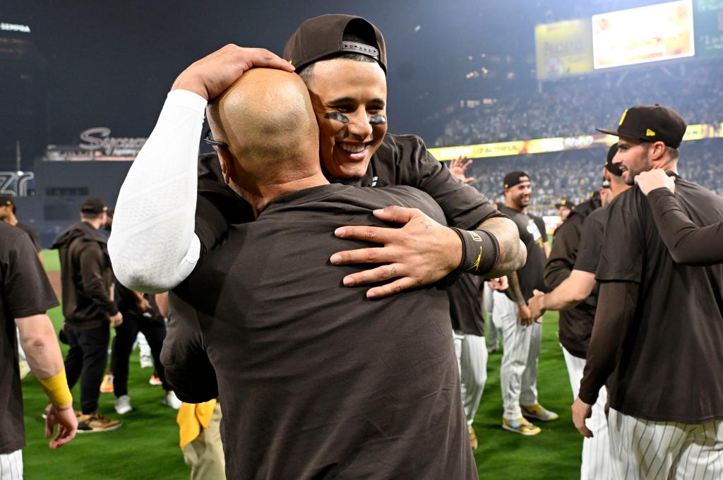 Manny Machado celebrates with teammates and coaches after the Padres' series-clinching win.