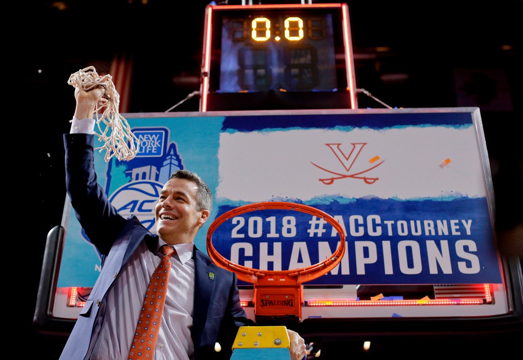 Virginia head coach Tony Bennett holds up the net after defeating North Carolina in the championship game of the NCAA Atlantic Coast Conference men's college basketball tournament in New York, March 10, 2018. 