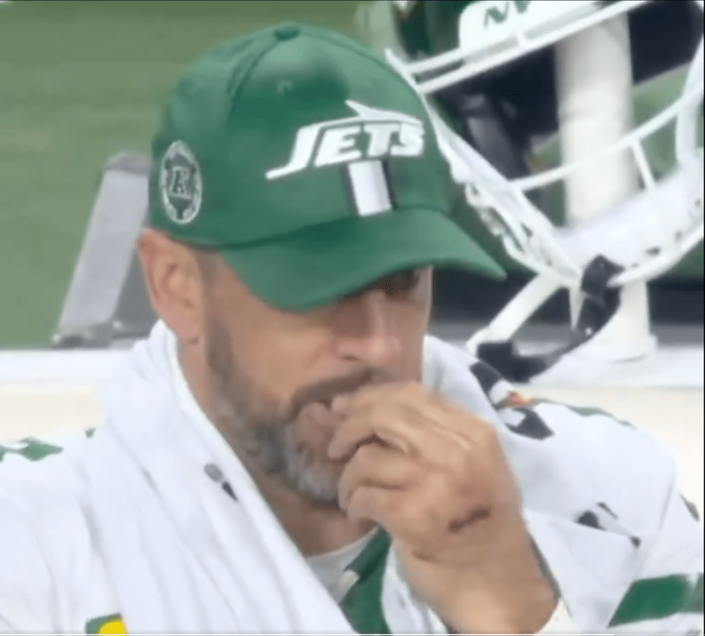 Aaron Rodgers appears to put his fingers in his mouth after swiping at his nose. 