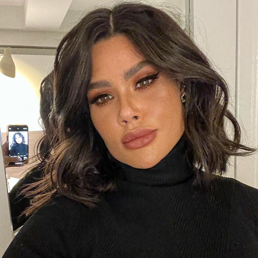 Adriana Vieira taking a selfie wearing a black turtleneck