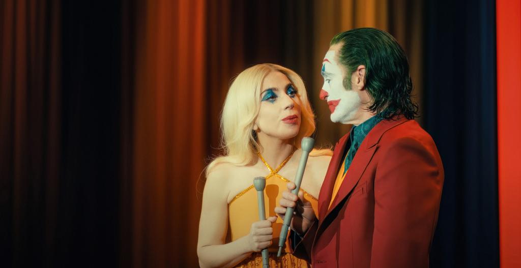 Lady Gaga as Harley Quinn and Joaquin Phoenix as Joker singing.