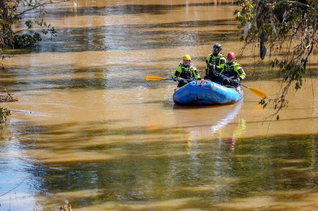 First responders paddling in a boat on the Swannanoa River in Asheville, NC, during the aftermath of Hurricane Helene's flooding