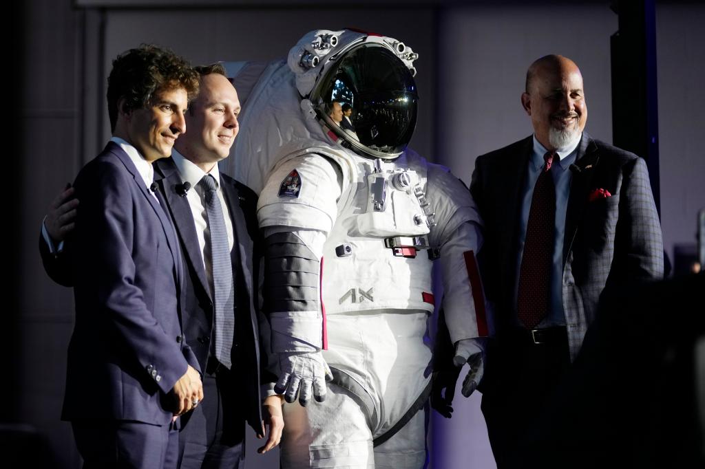 Axiom Space President Matt Ondler, Prada Group Chief Marketing Officer Lorenzo Bertelli, and Axiom Executive Vice President Russell Ralstom standing next to a Prada-designed spacesuit in Milan, Italy