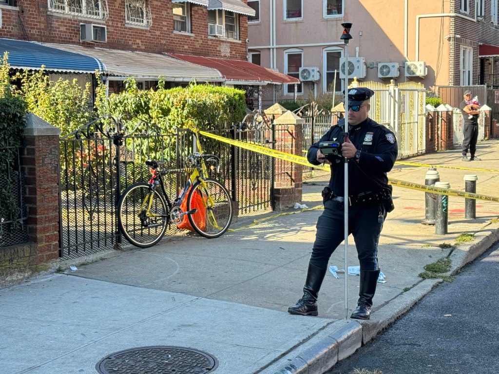 An NYPD investigator takes measurements at the crash site.