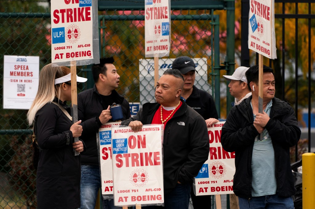 Boeing factory workers strike with signs on a picket line on Oct. 11, 2024.