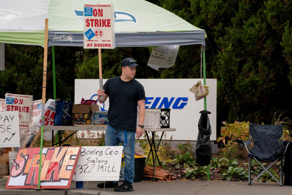 Boeing worker with signs on picket line on Oct. 11, 2024.