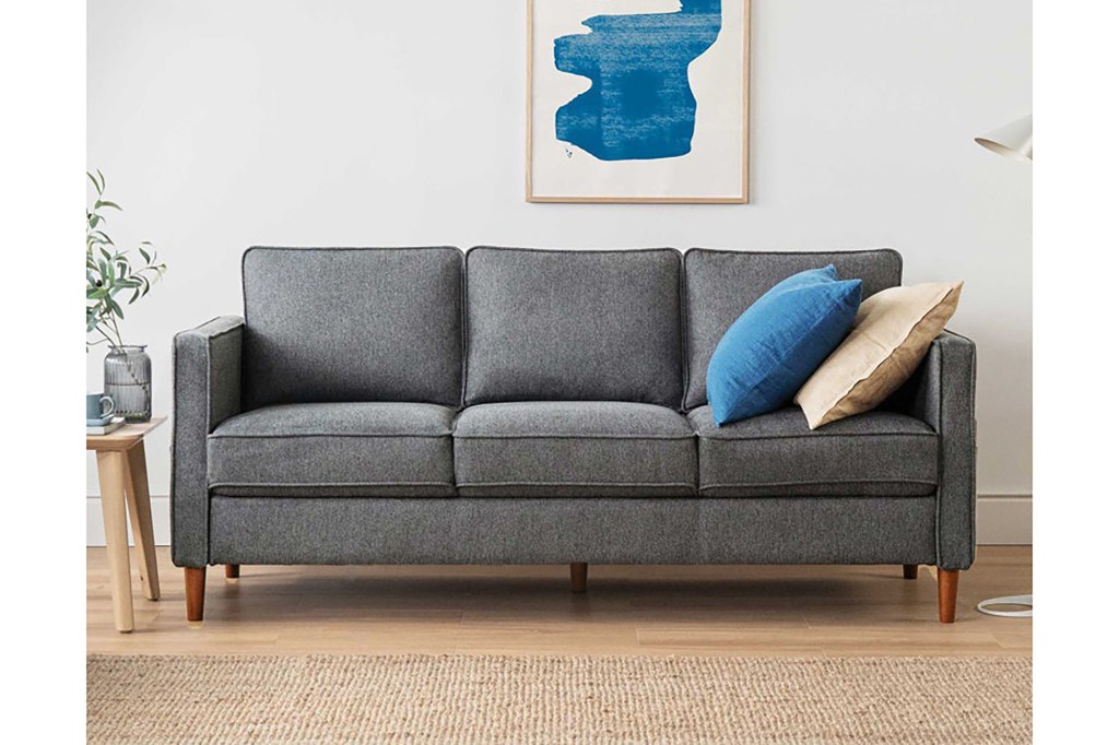 A grey couch with pillows on it