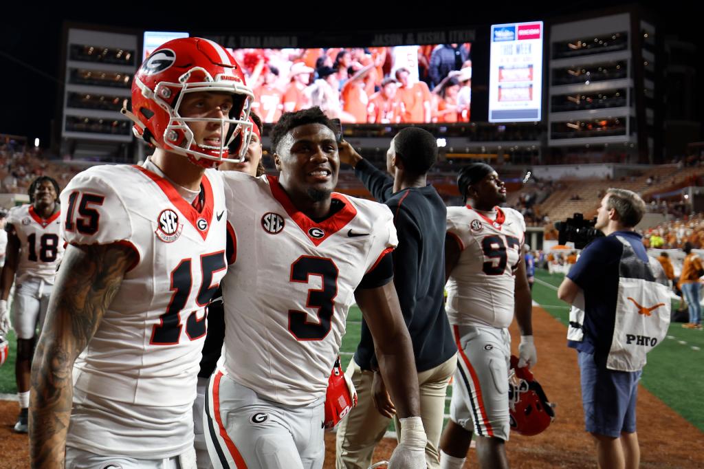 Carson Beck #15 and Nate Frazier #3 of the Georgia Bulldogs celebrate after defeating the Texas Longhorns on Oct. 19, 2024.