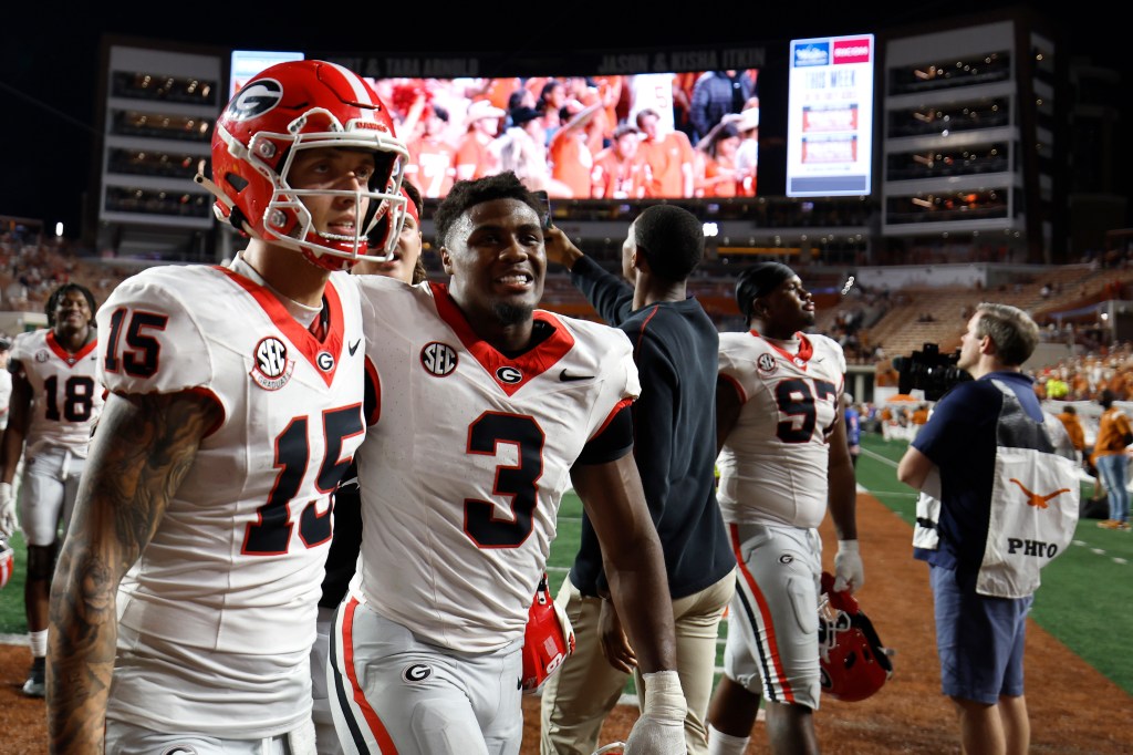 Carson Beck #15 and Nate Frazier #3 of the Georgia Bulldogs celebrate after defeating the Texas Longhorns on Oct. 19, 2024.