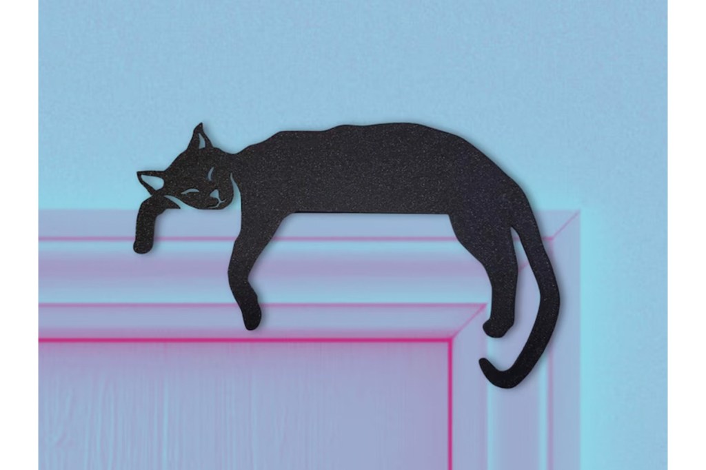 A black cat sitting on a ledge