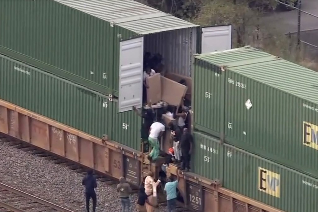 A group of ransackers form an "assembly line" and dole out the loot taken from cargo train.