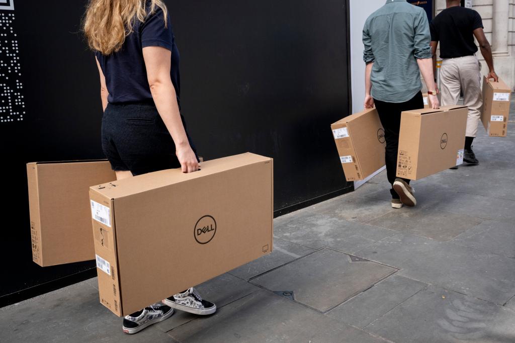 Dell employees carrying heavy boxes with Dell computers inside on Aug. 23, 2022.