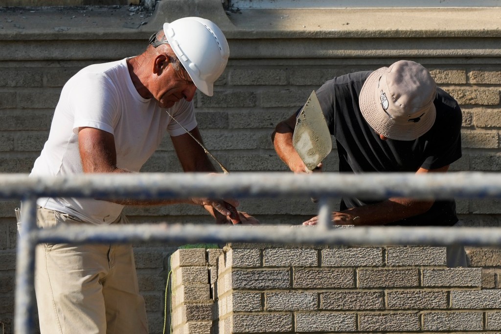 Construction workers are seen above at a residential building site in Chicago on Aug. 29, 2024.