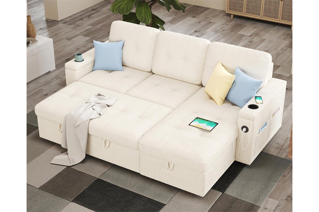 A white couch with pillows and a blanket on it