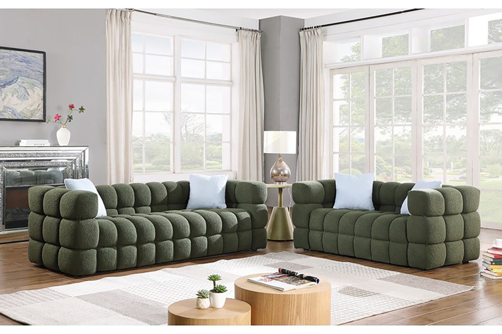 A living room with green couches and a coffee table