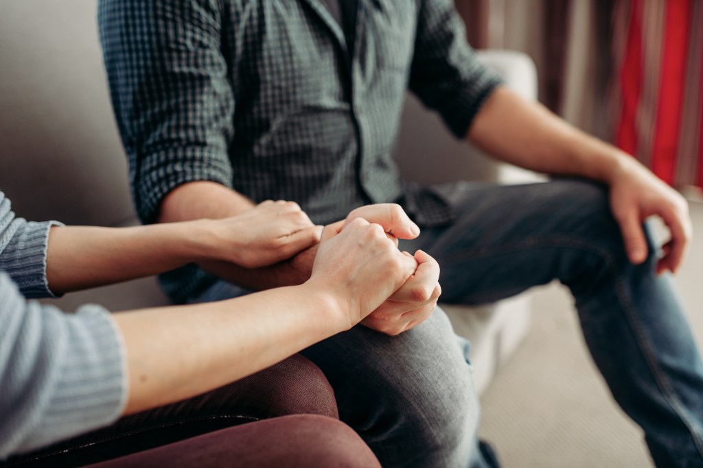 A couple holding hands at a psychologist's office for family support consultation